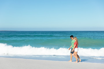 Young couple walking besides the beach