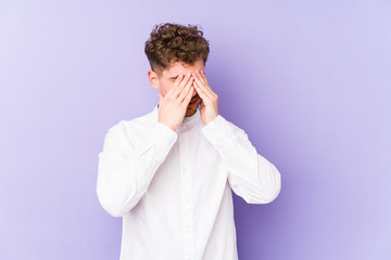 Young blond curly hair caucasian man isolated afraid covering eyes with hands.