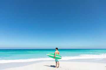 Young man with surfboard at the beach