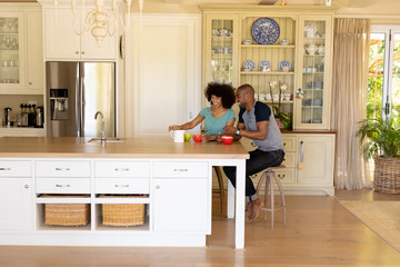 Happy young couple sitting at table in the kitchen