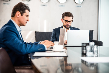 Focused business associates typing on their laptops