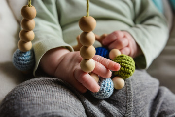 Baby's hands playing with nursing necklace
