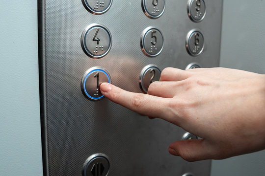 Female hand, finger presses the elevator button. up the career ladder.