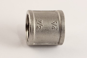 Inside thread 3/4" coupler sleeve, close up brass plumbing fixtures on white background