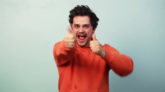 Guy show approval gesture on blue background