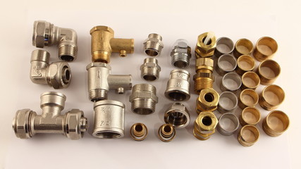 Plumbing equipment on white background - metal rings, connectors, sleeves, valves, fittings,...