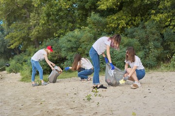 Group of students with teacher in nature doing cleaning of plastic garbage