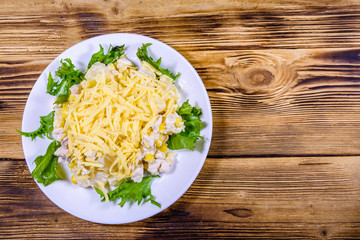 Festive salad with chicken breast, canned pineapple, cheese, sweet corn and mayonnaise on wooden...