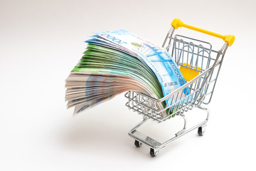 the toy cart is filled with banknotes. Russian money hanging in fans on a cart. White background