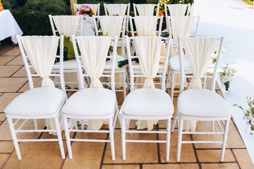 Empty white vintage wooden chairs for the wedding ceremony v. Summer outdoor event. Front view.