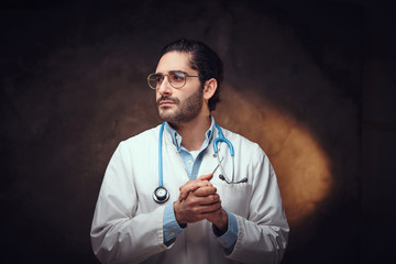 Tired medic in glasses is posing for photographer after a night shift.