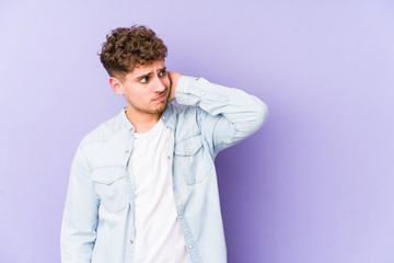 Fototapeta premium Young blond curly hair caucasian man isolated touching back of head, thinking and making a choice.