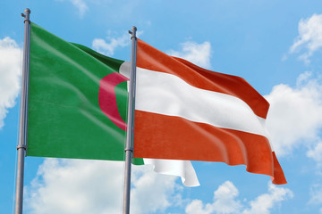 Austria and Algeria flags waving in the wind against white cloudy blue sky together. Diplomacy concept, international relations.
