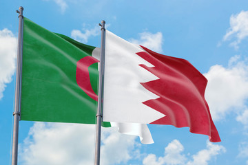 Bahrain and Algeria flags waving in the wind against white cloudy blue sky together. Diplomacy concept, international relations.