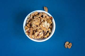 Walnuts texture top view on blue color background, space for text, organic healthy food concept