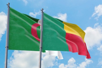 Benin and Algeria flags waving in the wind against white cloudy blue sky together. Diplomacy concept, international relations.
