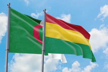 Bolivia and Algeria flags waving in the wind against white cloudy blue sky together. Diplomacy concept, international relations.