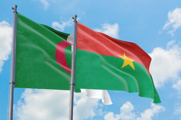 Burkina Faso and Algeria flags waving in the wind against white cloudy blue sky together. Diplomacy concept, international relations.