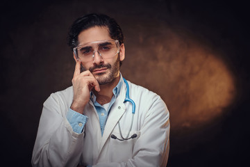 Young handsome medic is posing for photographer wearing protective goggles.
