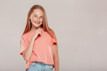 Inclusive Beauty. Girl with freckles standing isolated on grey posing smiling playful