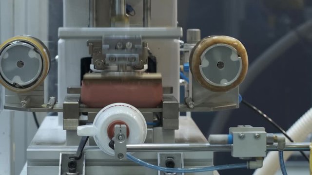 A robot at the factory applies the brand name to plastic glasses using pad printing.