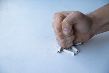 Nicotine addiction - stop killing yourself. Fist on cigarette butts. Broken cigarette in the hands....
