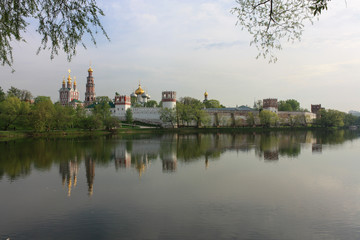 Fototapeta na wymiar Novodevichy monastery in cloudy weather with reflections in summer evening, Moscow, Russia