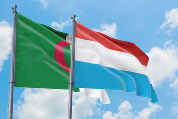 Luxembourg and Algeria flags waving in the wind against white cloudy blue sky together. Diplomacy concept, international relations.