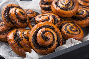 Puff curls with fruit, jam, berries on a black table with a blue napkin. Puff pastry on a wooden board and a black wooden table. Fresh French Homemade Puff curls pastry. Warm Fresh Buttery Rolls.