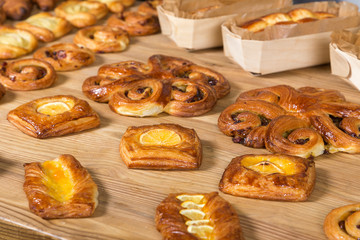 Different kinds of fresh bread on a table. Assortment of fresh bakery products on wooden table.