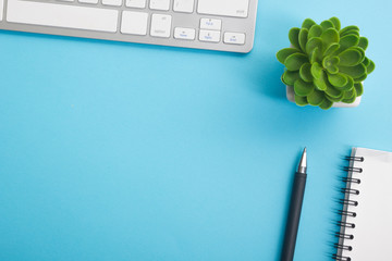 Blue desk office with laptop, smartphone and other work supplies with cup of coffee. Top view with...