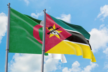 Mozambique and Algeria flags waving in the wind against white cloudy blue sky together. Diplomacy...