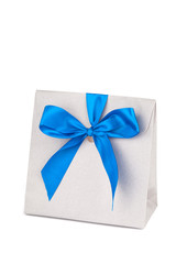 Gray gift paper bag with a blue ribbon on a white background. Gift wrapping, holiday.