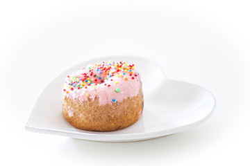 Heart Shaped plate with pink donut on white background