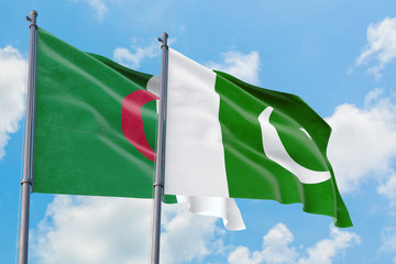 Pakistan and Algeria flags waving in the wind against white cloudy blue sky together. Diplomacy concept, international relations.