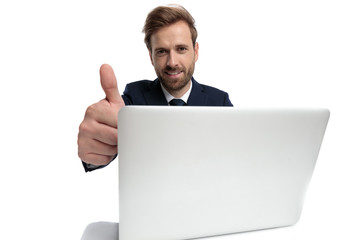 happy young businessman making thumbs up sign