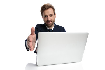 young businessman in navy blue suit smiling and shaking hand