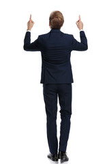 young businessman in navy blue suit pointing fingers up