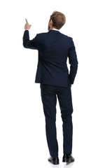 young businessman in navy blue suit pointing finger up