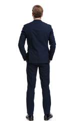 young businessman in navy blue suit holding hands in pockets