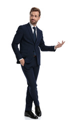 confident businessman smiling and presenting to side