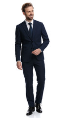 happy businessman in navy blue suit smiling and looking to side