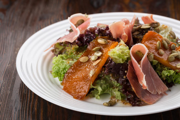 Delicious fresh salad. Salad with prosciutto, olive oil. Close up view on Salad. Healthy, diet tasty summer dish