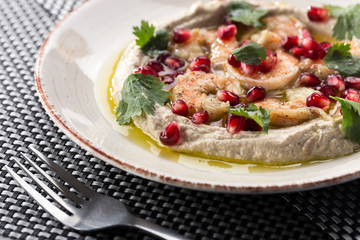 Hummus with olive oil. Hummus platter with assorted snacks. Hummus in bowl.