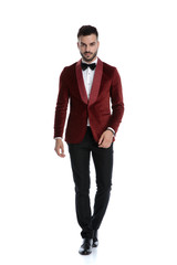 Fototapeta premium cool fashion man in red velvet tuxedo walking