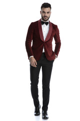 sexy young man in red velvet tuxedo holding hand in pocket