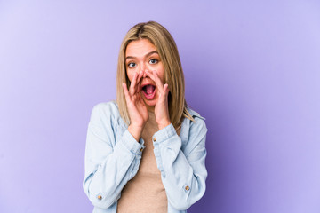 Young blonde caucasian woman isolated shouting excited to front.