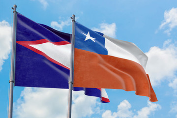 Chile and American Samoa flags waving in the wind against white cloudy blue sky together. Diplomacy concept, international relations.