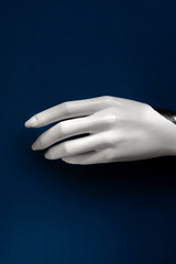 Mannequin hand on a blue background. Art model for drawing. Part of the body - hand, brush. Mannequin for displaying clothes, jewelry. Mannequin for the artist. Color of the year 2020 classic blue.