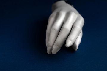 Mannequin hand on a blue background. Art model for drawing. Part of the body - hand, brush. Mannequin for displaying clothes, jewelry. Mannequin for the artist. Color of the year 2020 classic blue.